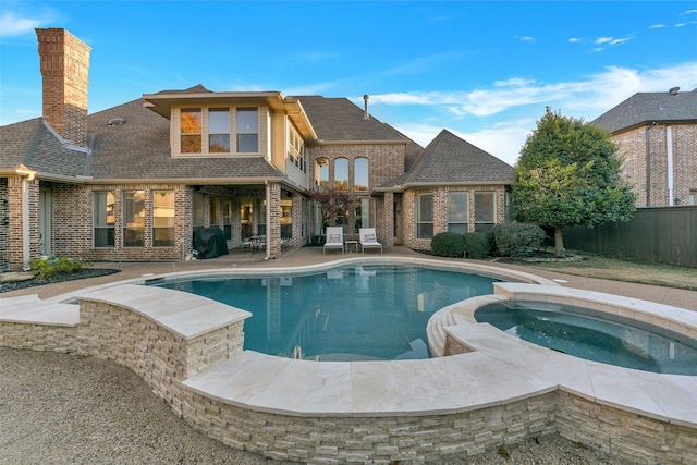 view of pool with an in ground hot tub, grilling area, and a patio area