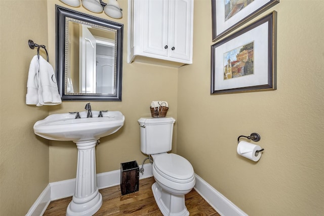 bathroom featuring hardwood / wood-style flooring, toilet, and sink