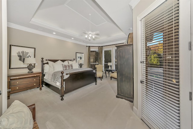 bedroom with ornamental molding, light carpet, ceiling fan, and a tray ceiling