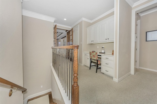 interior space featuring crown molding, light carpet, and built in desk