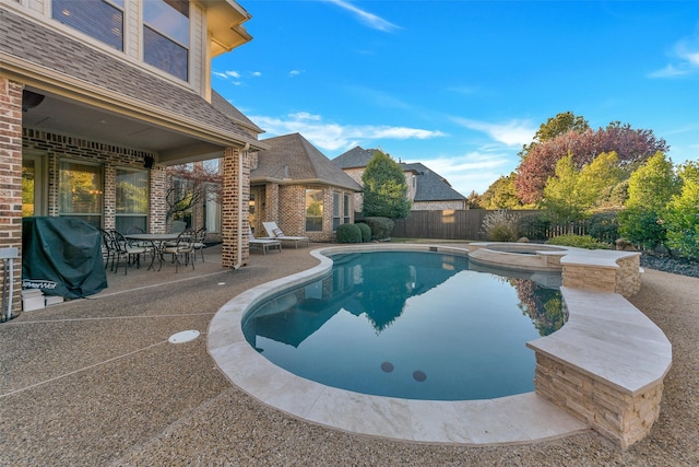 view of pool with grilling area, a patio area, and an in ground hot tub