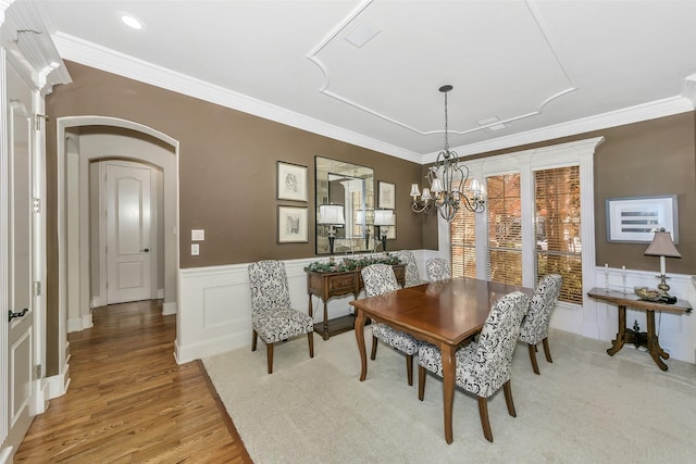 dining area featuring a notable chandelier, ornamental molding, and light hardwood / wood-style floors