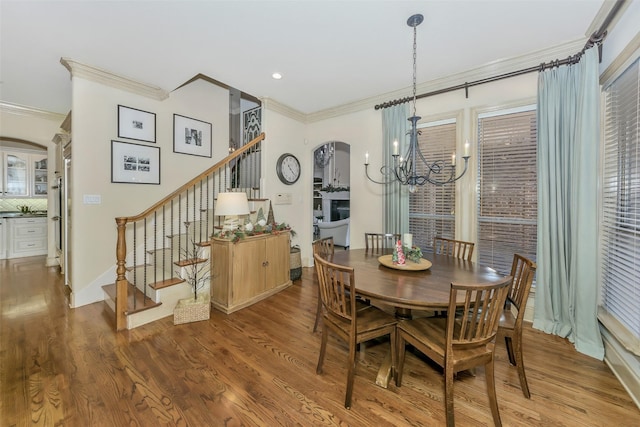 dining room with crown molding, hardwood / wood-style floors, and a notable chandelier