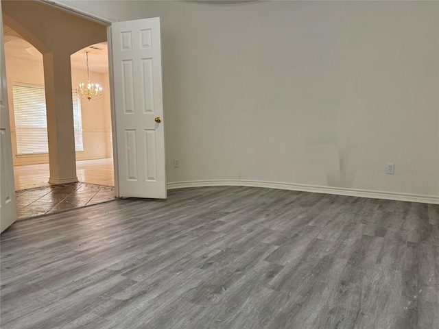 unfurnished room with dark hardwood / wood-style flooring and an inviting chandelier