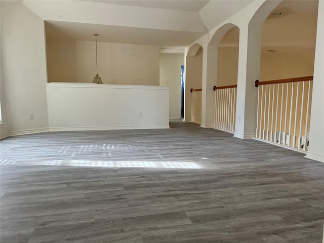 unfurnished room featuring a high ceiling and dark hardwood / wood-style floors