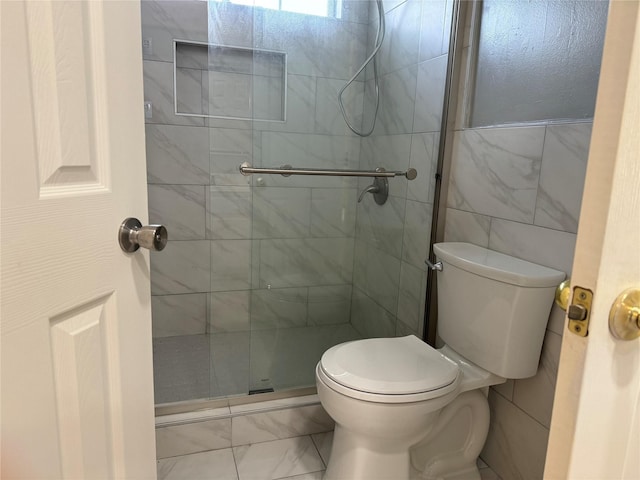 bathroom with tiled shower, tile walls, and toilet