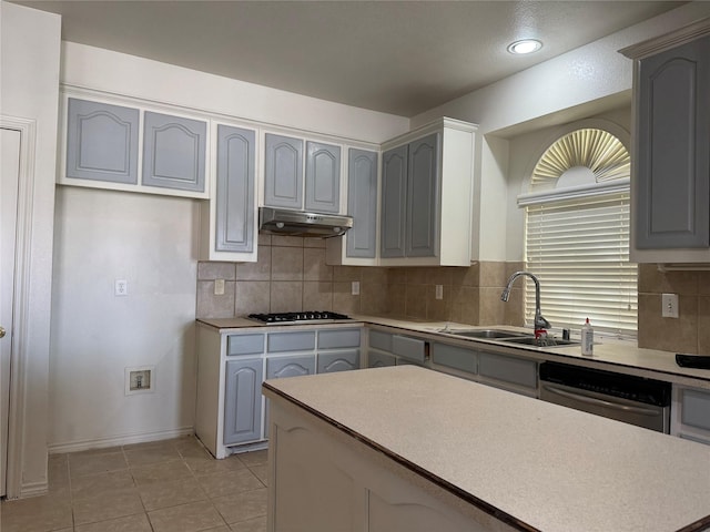 kitchen with decorative backsplash, appliances with stainless steel finishes, sink, light tile patterned floors, and gray cabinets