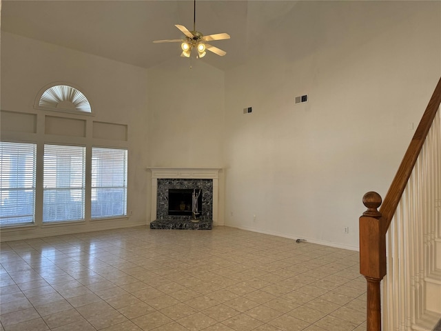 unfurnished living room featuring ceiling fan, light tile patterned floors, a fireplace, and high vaulted ceiling