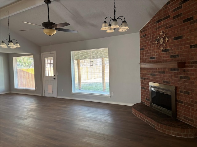 unfurnished living room with ceiling fan with notable chandelier, lofted ceiling with beams, dark hardwood / wood-style floors, and a brick fireplace