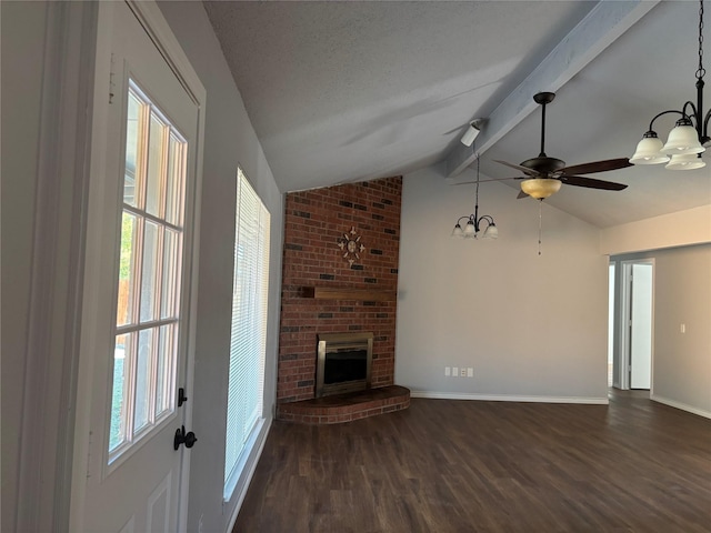 unfurnished living room featuring dark hardwood / wood-style flooring, vaulted ceiling with beams, a brick fireplace, and a wealth of natural light