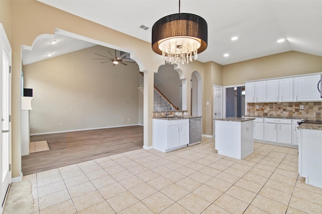 kitchen with backsplash, a kitchen island, light hardwood / wood-style flooring, white cabinetry, and hanging light fixtures