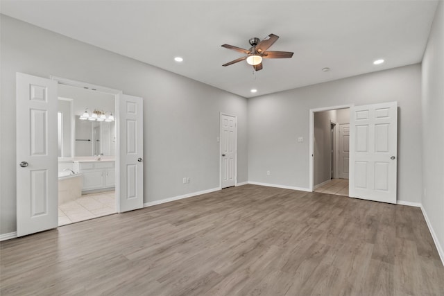 unfurnished bedroom with ceiling fan, sink, ensuite bathroom, a closet, and light wood-type flooring