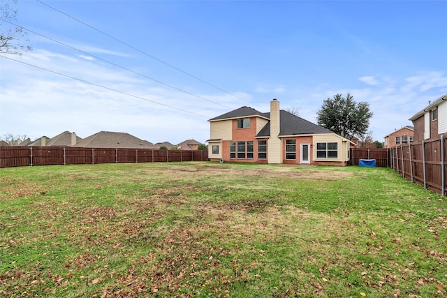 rear view of property featuring a lawn