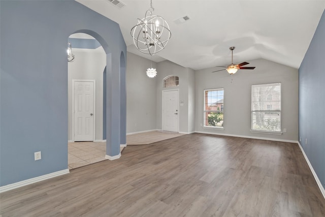 unfurnished room with lofted ceiling, light hardwood / wood-style flooring, and ceiling fan with notable chandelier