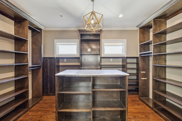 walk in closet with dark wood-type flooring and an inviting chandelier