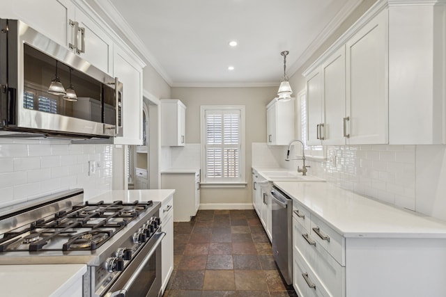 kitchen featuring hanging light fixtures, white cabinetry, sink, and stainless steel appliances