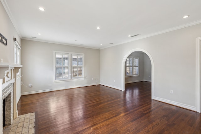 unfurnished living room featuring a fireplace, ornamental molding, and dark wood-type flooring