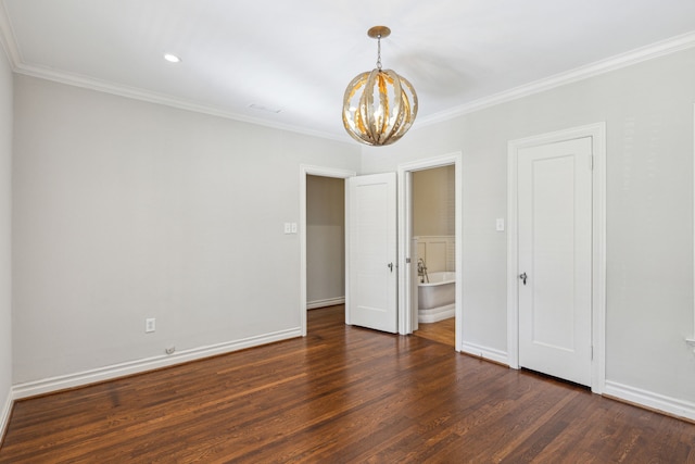 unfurnished room featuring a chandelier, ornamental molding, and dark wood-type flooring