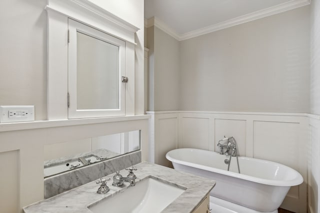 bathroom with a bathing tub, crown molding, and vanity