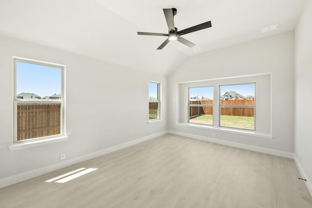 spare room featuring visible vents, baseboards, ceiling fan, vaulted ceiling, and wood finished floors