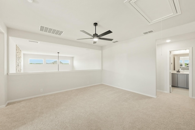 unfurnished room featuring light carpet, visible vents, and attic access