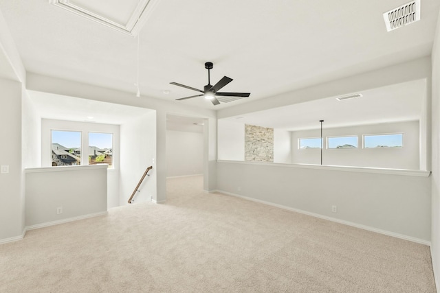 carpeted empty room featuring visible vents, a wealth of natural light, and baseboards