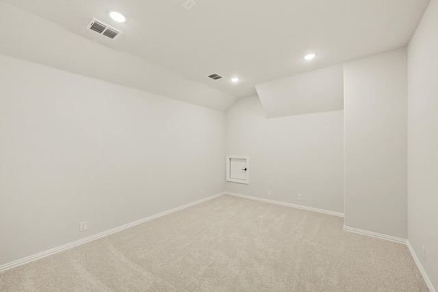 empty room featuring baseboards, recessed lighting, light carpet, and lofted ceiling