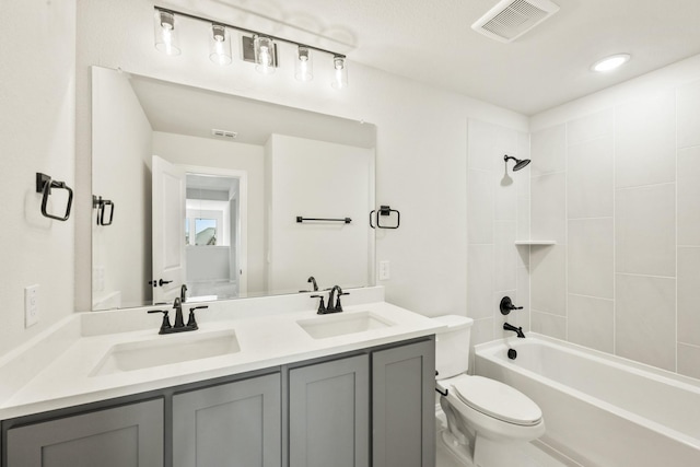 bathroom featuring double vanity, visible vents, a sink, and toilet