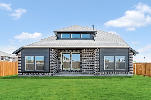 back of property with a yard, roof with shingles, and a fenced backyard