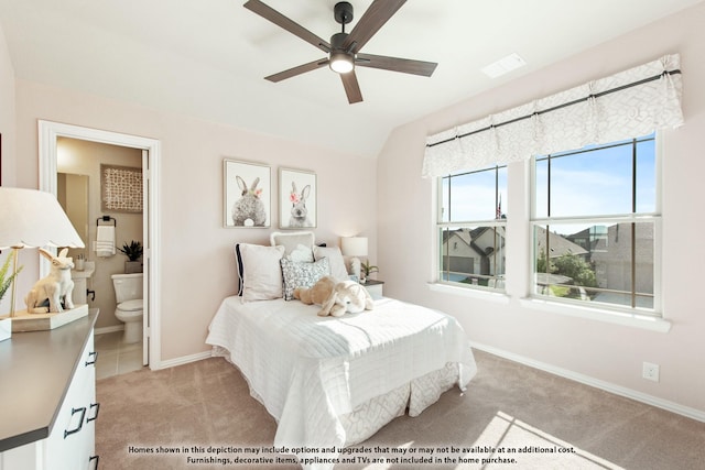 bedroom with ceiling fan, light colored carpet, ensuite bathroom, and lofted ceiling