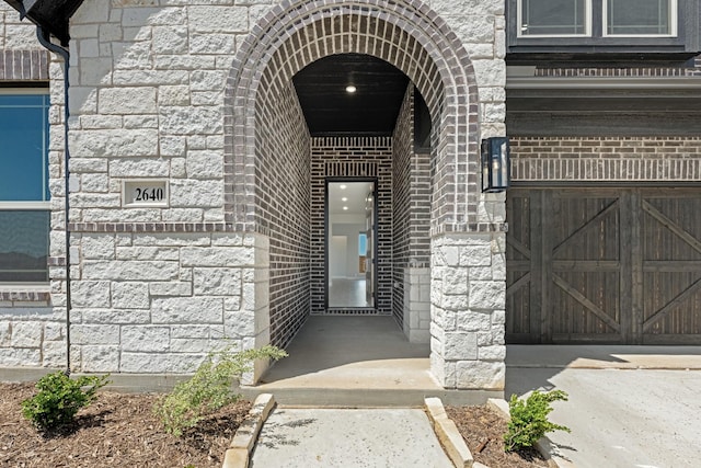 property entrance featuring brick siding and stone siding