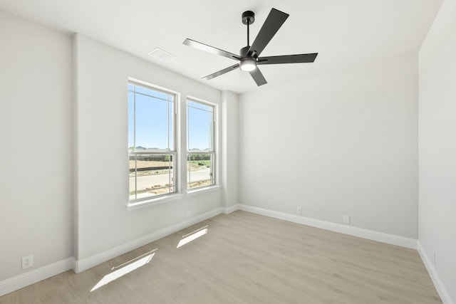 unfurnished room featuring visible vents, light wood-style flooring, ceiling fan, and baseboards