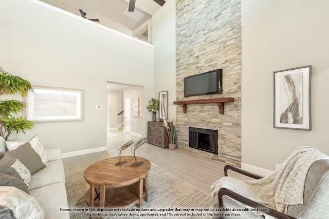 living room with ceiling fan and a stone fireplace