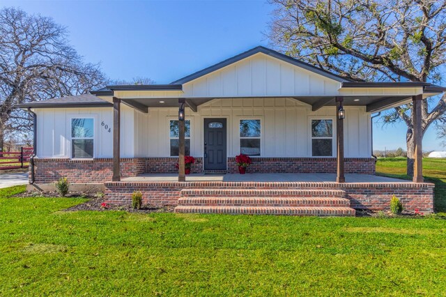 view of front of home with covered porch and a front yard