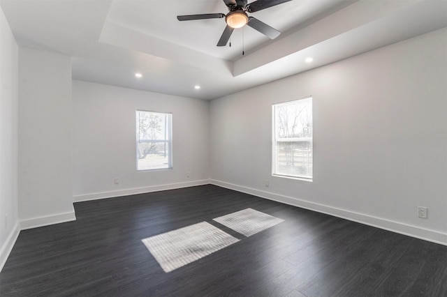 spare room with a wealth of natural light, ceiling fan, and dark wood-type flooring