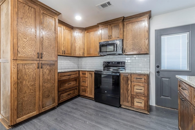 kitchen featuring tasteful backsplash, visible vents, brown cabinets, dark wood-style floors, and black / electric stove