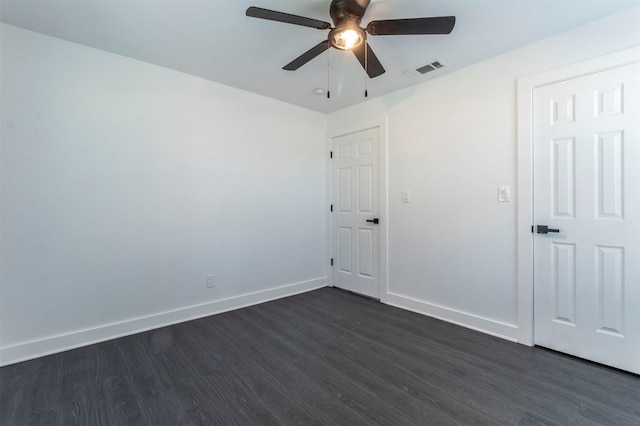 unfurnished bedroom with dark wood-style floors, visible vents, ceiling fan, and baseboards