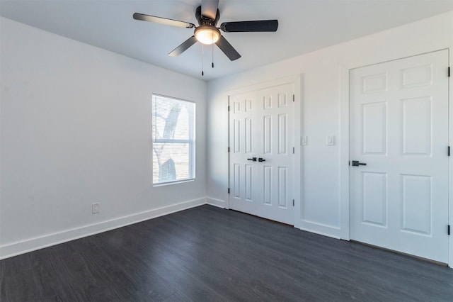 unfurnished bedroom featuring ceiling fan and dark hardwood / wood-style flooring