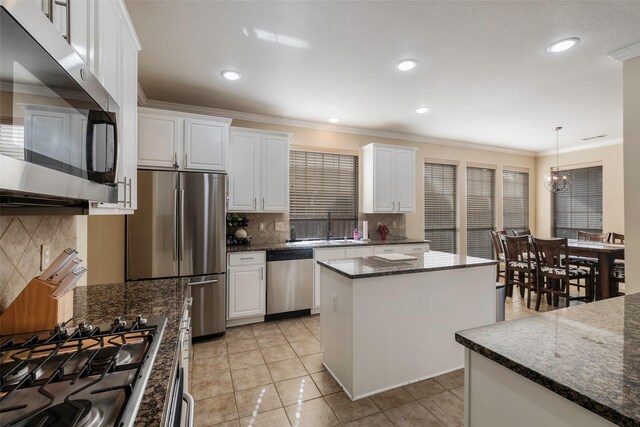 kitchen with white cabinetry, decorative light fixtures, sink, dishwasher, and a center island