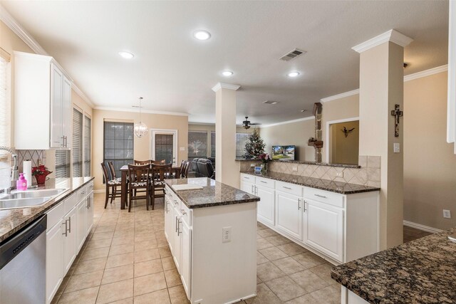 kitchen with kitchen peninsula, appliances with stainless steel finishes, white cabinetry, and dark stone counters