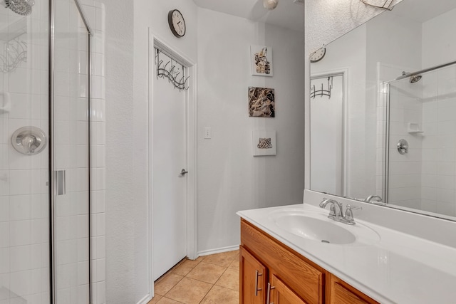 bathroom featuring tile patterned flooring, vanity, and a shower with shower door