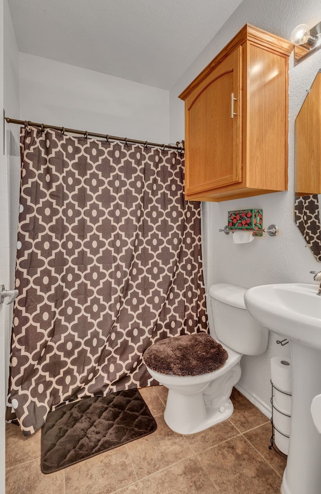 bathroom featuring toilet, walk in shower, and sink