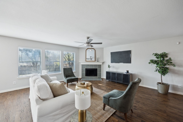 living room featuring ceiling fan, dark hardwood / wood-style flooring, and a tile fireplace