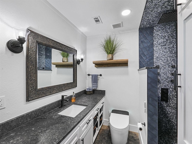 bathroom with vanity, toilet, and tiled shower