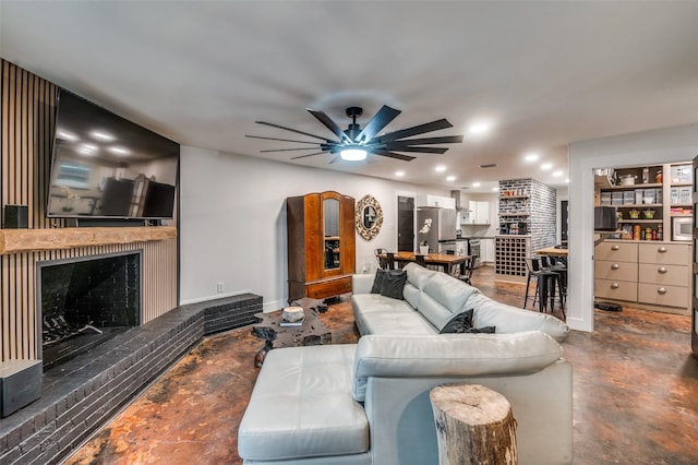 living room with ceiling fan and a fireplace