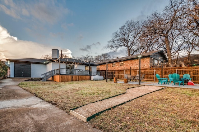 yard at dusk with a garage and a patio area