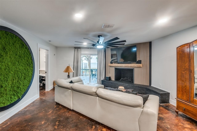 living room with ceiling fan and a fireplace