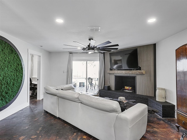 living room with ceiling fan and a fireplace