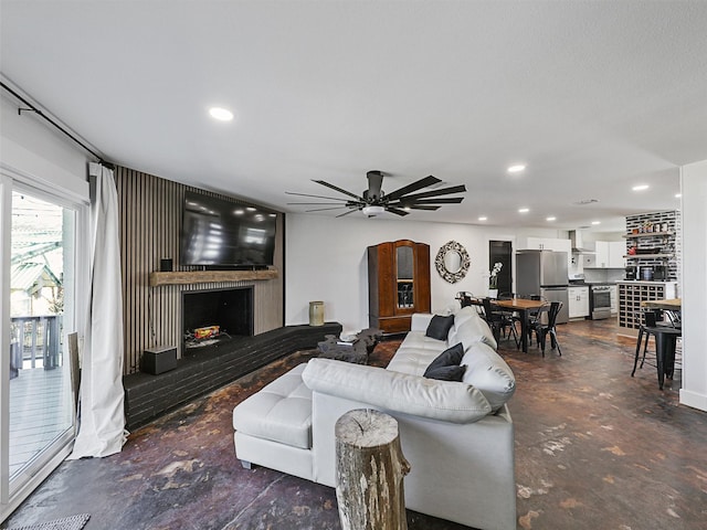 living room with a large fireplace and ceiling fan