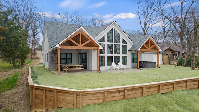 rear view of property with a lawn, a patio, and a hot tub